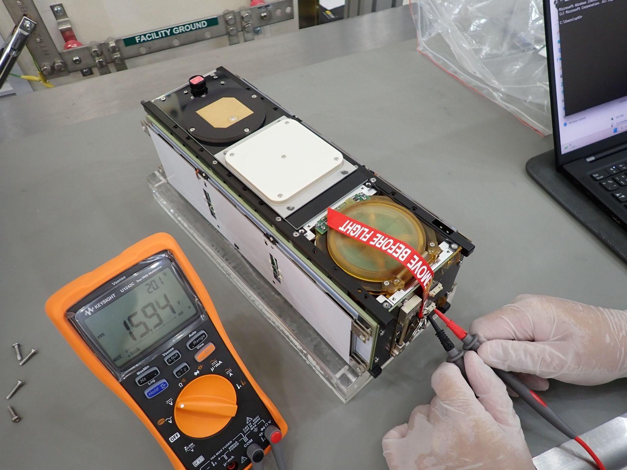 A LOGSATS-2 flight unit under bench test with a remove-before-flight streamer attached
