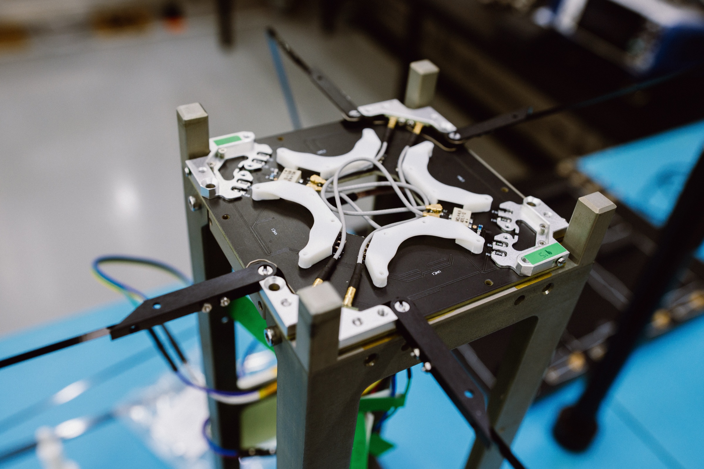 CubeSat flight unit with deployed antenna system on the integration bench